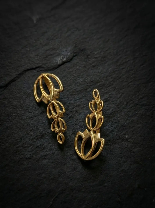 Gold climber earring in a floral design worn by model