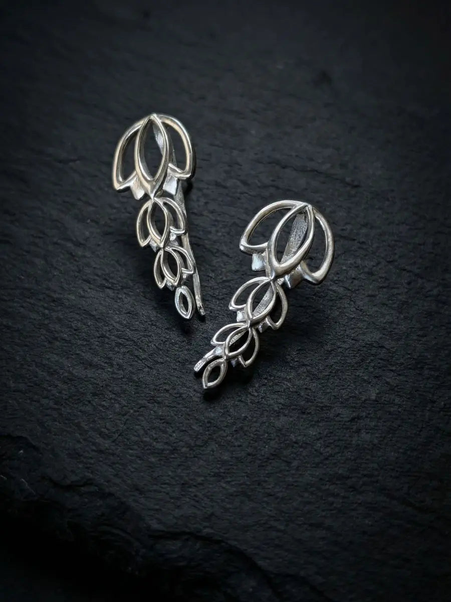 Silver climber earring in a floral design worn by model