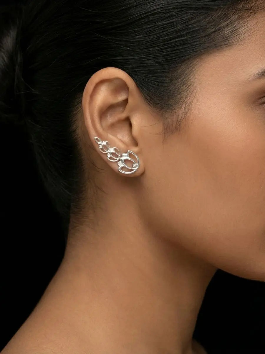 Silver climber earring in a floral design worn by model